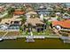 Aerial view showcases waterfront property with boat dock, screened lanai and private pool, set among lush landscaping at 3335 Grenada Ct, Punta Gorda, FL 33950