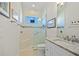 Bright bathroom features a glass shower with a built-in seat and a view outside through a window at 3335 Grenada Ct, Punta Gorda, FL 33950