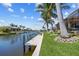 Beautiful canal view featuring a private dock, lush green lawn, and inviting waterfront living at 3335 Grenada Ct, Punta Gorda, FL 33950