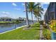 Waterfront canal view with a private dock, green grass, landscaping, and access to boating and recreation at 3335 Grenada Ct, Punta Gorda, FL 33950