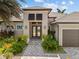 Elegant front entrance with double doors, well-manicured landscaping, and paver walkway at 3335 Grenada Ct, Punta Gorda, FL 33950