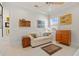 Bright living room features a couch, neutral decor, and natural light from a window with shutters at 3335 Grenada Ct, Punta Gorda, FL 33950