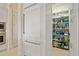 Large walk-in pantry featuring custom shelving and stainless steel refrigerator at 3335 Grenada Ct, Punta Gorda, FL 33950