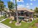 Back of house boasts a screened lanai area that features a pool and an outdoor seating, surrounded by mature palm trees at 3335 Grenada Ct, Punta Gorda, FL 33950