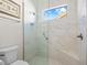 Bright bathroom features a glass shower with a built-in seat and a view outside through a window at 3335 Grenada Ct, Punta Gorda, FL 33950