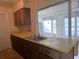 Galley kitchen featuring laminate countertops, window, and overhead cabinets at 410 Hinton St, Port Charlotte, FL 33954