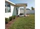 Exterior showing a covered patio with seating, landscaped flower beds, and privacy fence at 43735 Cattleman Dr, Punta Gorda, FL 33982