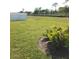 Backyard view showing a manicured lawn, privacy fence, and mature landscaping at 43735 Cattleman Dr, Punta Gorda, FL 33982