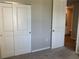 Bedroom with neutral paint, plush carpet, and a doorway leading to the bathroom at 43735 Cattleman Dr, Punta Gorda, FL 33982