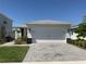 Charming home exterior with a wide driveway, attached garage, and manicured lawn at 43735 Cattleman Dr, Punta Gorda, FL 33982