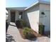Home exterior view featuring a covered entrance, manicured shrubs, brick paver walkway, and neutral paint at 43735 Cattleman Dr, Punta Gorda, FL 33982