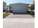 Home exterior featuring a two car garage, brick paver driveway, manicured lawn, and neutral paint at 43735 Cattleman Dr, Punta Gorda, FL 33982