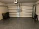 Spacious garage with speckled floor, overhead door with opener, and convenient trash receptacles at 43735 Cattleman Dr, Punta Gorda, FL 33982