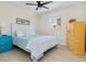 Cozy bedroom featuring a queen bed, bright colored furniture, and a ceiling fan at 5031 N Beach Rd # C-124, Englewood, FL 34223