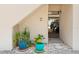 Entrance to condo featuring colorful potted plants with a glimpse of the garage and cars at 5031 N Beach Rd # C-124, Englewood, FL 34223