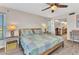 Bedroom with light wood floors, a ceiling fan, and view to the bathroom and desk area at 601 Shreve St # 36C, Punta Gorda, FL 33950