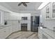 Modern kitchen with stainless steel appliances, white cabinetry, granite countertops, and hardwood flooring at 609 Macedonia Dr, Punta Gorda, FL 33950