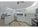 Bright, airy kitchen with stainless appliances, white cabinetry, and a view overlooking the outdoor pool area at 609 Macedonia Dr, Punta Gorda, FL 33950