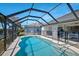 Enclosed pool area with an in-ground pool, patio, and views of the surrounding greenery and neighboring homes at 609 Macedonia Dr, Punta Gorda, FL 33950