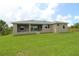Rear exterior elevation of the house with a covered lanai, lawn, and sliding glass doors at 9529 Calumet Blvd, Port Charlotte, FL 33981
