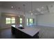 Bright kitchen with island, stainless sink, pendant lights, view to the living room and screened patio at 9529 Calumet Blvd, Port Charlotte, FL 33981