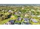 This aerial shot showcases a neighborhood with spacious homes, mature trees, and a nearby lake at 1068 Harbour Cape Pl, Punta Gorda, FL 33983