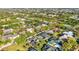 Aerial view of a charming neighborhood featuring well-maintained homes, mature trees, and a tennis court at 1068 Harbour Cape Pl, Punta Gorda, FL 33983