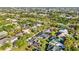 An aerial view reveals a community with manicured lawns, mature trees, and homes with screened pools at 1068 Harbour Cape Pl, Punta Gorda, FL 33983