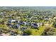 An aerial view displays the neighborhood homes nestled among trees at 1068 Harbour Cape Pl, Punta Gorda, FL 33983