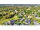 An aerial shot displays the neighborhood homes nestled among trees with water in the distance at 1068 Harbour Cape Pl, Punta Gorda, FL 33983