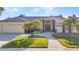 Single-story home featuring mature palm trees, well-manicured lawn, and a two-car garage at 1068 Harbour Cape Pl, Punta Gorda, FL 33983