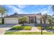 Traditional single-story home with a three car garage, manicured lawn, and mature landscaping at 1068 Harbour Cape Pl, Punta Gorda, FL 33983