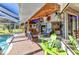 Outdoor lanai featuring a cozy seating area, full bar, and lush landscaping, perfect for outdoor living at 1068 Harbour Cape Pl, Punta Gorda, FL 33983
