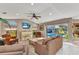 Sun-filled living room with piano, comfortable seating, and views of the screened pool at 1068 Harbour Cape Pl, Punta Gorda, FL 33983