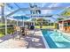 Lovely in-ground pool with dining area with umbrella, creating a perfect spot for outdoor dining and lounging at 1068 Harbour Cape Pl, Punta Gorda, FL 33983