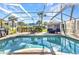 Inviting pool area with a screened enclosure, comfortable seating, and lush landscaping, ideal for relaxation at 1068 Harbour Cape Pl, Punta Gorda, FL 33983