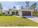 Charming single-story home boasts a manicured lawn, brown garage door, and a welcoming double-door entrance at 111 Swan Dr, Rotonda West, FL 33947
