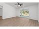 Bright living room boasts wood-look floors, ceiling fan, and sliding glass doors to the backyard at 111 Swan Dr, Rotonda West, FL 33947