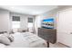 Cozy bedroom with a comfortable bed, dresser with TV, two windows, and two armchairs at 14289 Manatee Rd, Parrish, FL 34219