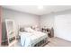 Bright bedroom features a white metal bed frame, wood floors, and a full length mirror at 14289 Manatee Rd, Parrish, FL 34219