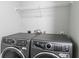Modern laundry room featuring front-load washer and dryer, and a white wire shelf for organized storage at 14289 Manatee Rd, Parrish, FL 34219