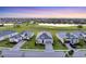 Beautiful aerial view of single-Gathering homes, a large green space and a pond at sunset at 14381 Heritage Landing Blvd, Punta Gorda, FL 33955