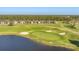 Aerial view of a golf course community featuring a lake and well-maintained greenery at 14381 Heritage Landing Blvd, Punta Gorda, FL 33955