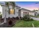 Close up exterior of a single-Gathering home showcasing the lush landscaping and a grey brick driveway at 14381 Heritage Landing Blvd, Punta Gorda, FL 33955