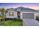 Inviting front exterior of a single-Gathering home with a gray driveway and manicured lawn at 14381 Heritage Landing Blvd, Punta Gorda, FL 33955