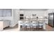 Modern kitchen featuring white cabinetry, stainless steel appliances, granite countertops, and a breakfast bar with seating at 14381 Heritage Landing Blvd, Punta Gorda, FL 33955