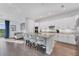 Open kitchen with white cabinets, granite countertops, a large island with seating, and stainless steel appliances at 14381 Heritage Landing Blvd, Punta Gorda, FL 33955