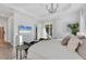 Bright main bedroom with chandelier lighting, television, tray ceilings, and lanai access at 14381 Heritage Landing Blvd, Punta Gorda, FL 33955