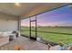Spacious screened-in patio with brick flooring, comfortable seating and a scenic sunset view at 14381 Heritage Landing Blvd, Punta Gorda, FL 33955
