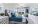 Well-lit bedroom featuring a queen size bed with plush pillows and a dresser, nightstand, and modern chandelier light fixture at 16290 Maya Cir, Punta Gorda, FL 33955